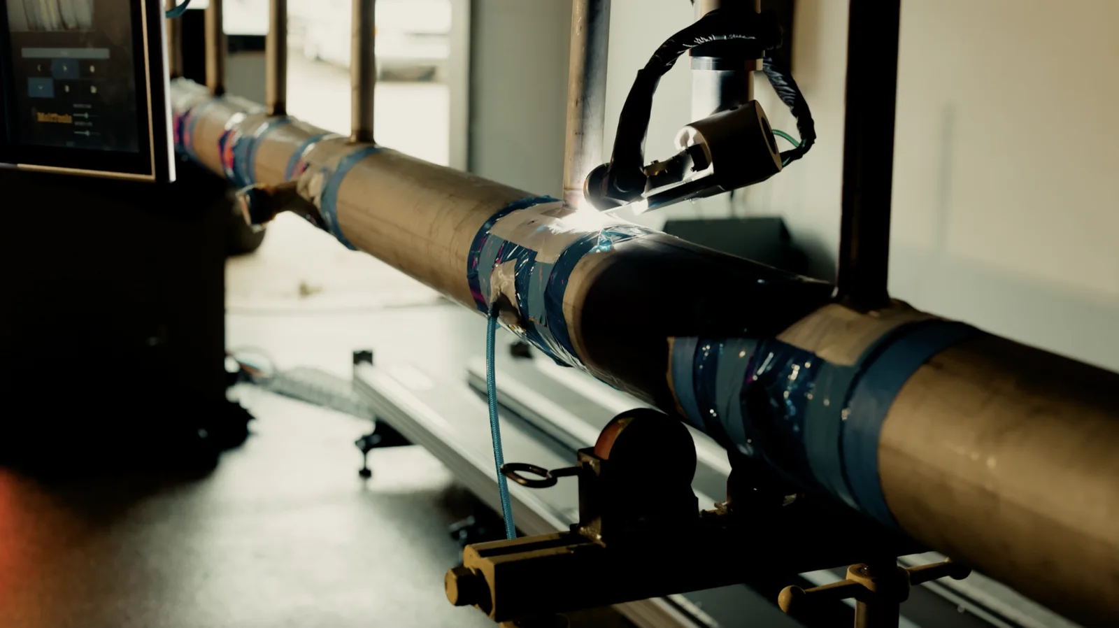 Close view of a pulled-tee header branch under the AutonoWeld M4 welding torch